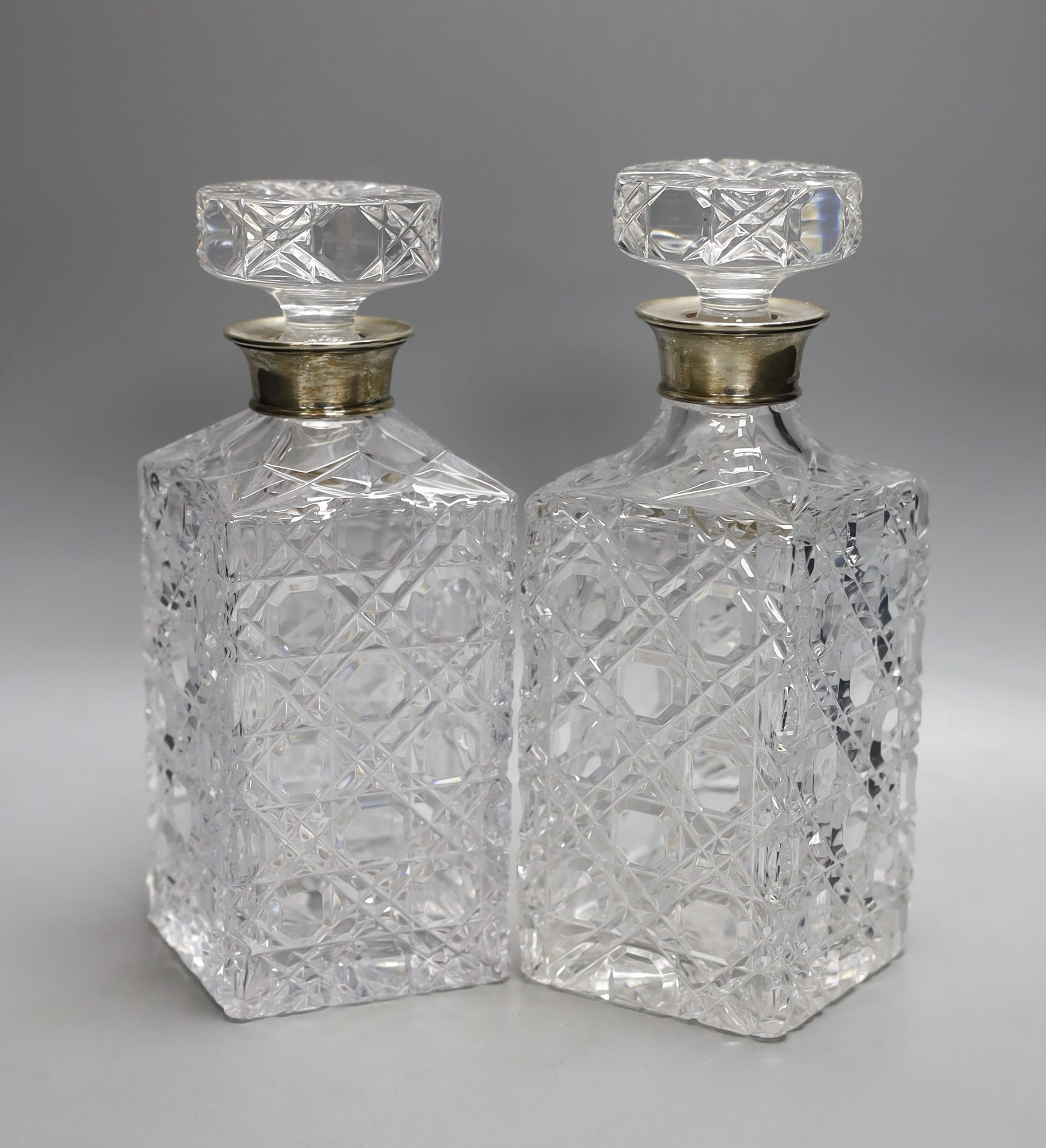 A pair of silver mounted cut glass decanters and stoppers, 23.5cm